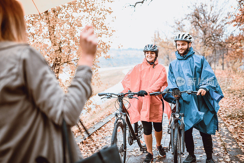一对骑自行车的夫妇在公园里和他们的朋友见面
