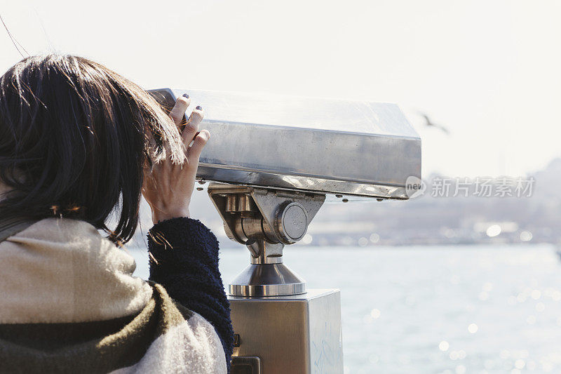 游客通过双筒望远镜看伊斯坦布尔的城市景观