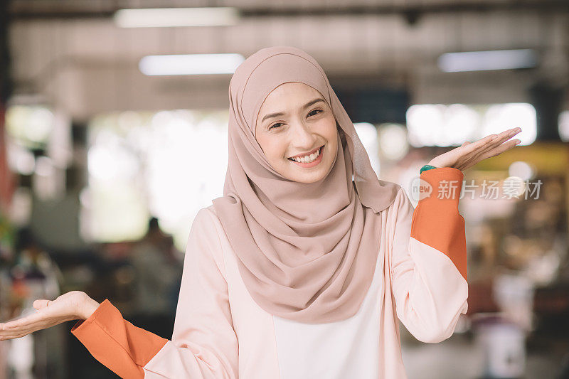 一名亚洲穆斯林女性早上在户外的菜市场以积极的情绪爆头