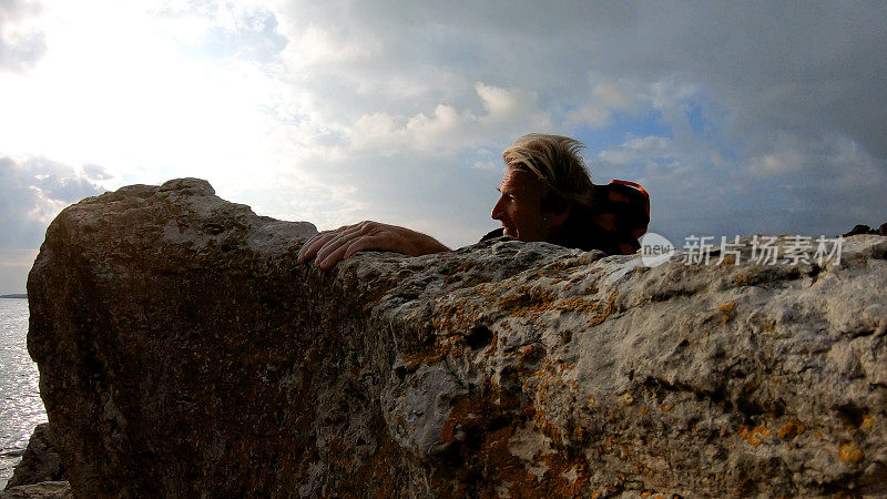 一个登山者横越岩石峰顶