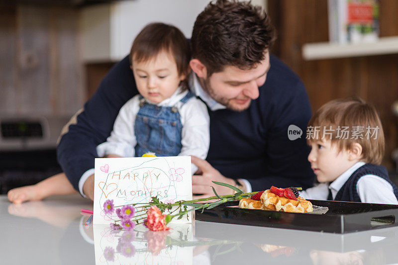 一个家庭在床上为他们的妈妈准备早餐