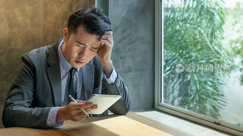 沮丧的商人在咖啡馆使用数字平板电脑