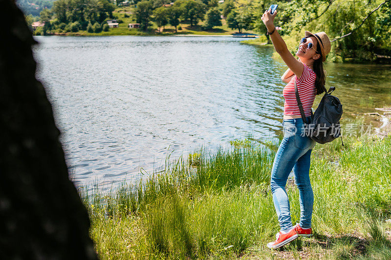 在湖边自拍的女人