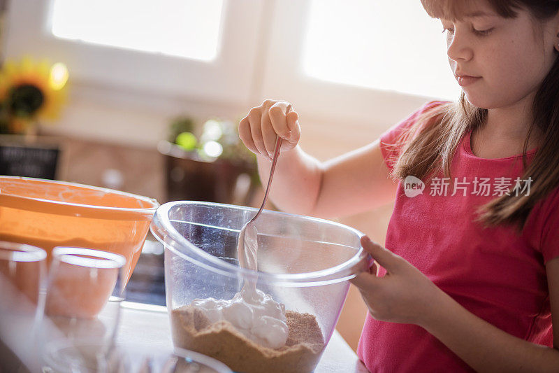 女孩在蛋糕混合物中加入鲜奶油