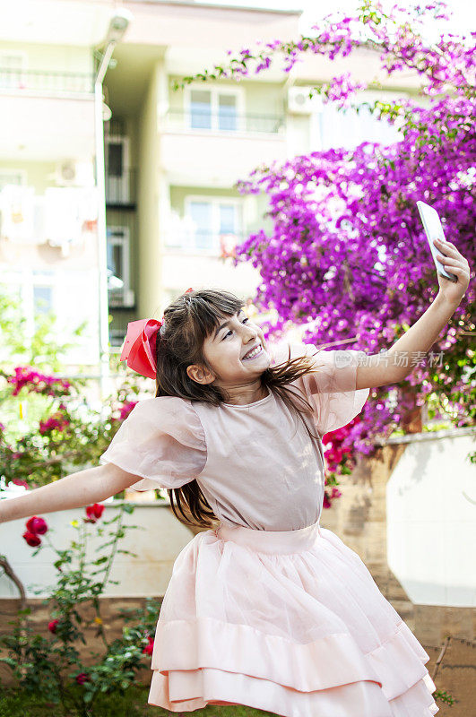 小女孩在花园里用手机