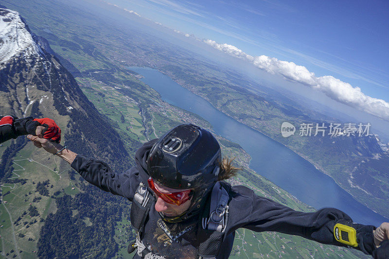 自由落体飞行者通过高山景观之上的崇高天空下降