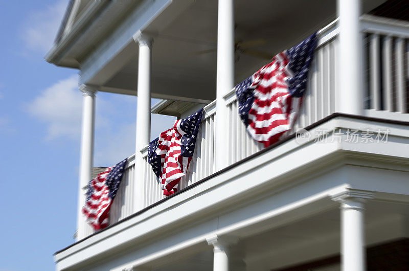 为了庆祝即将到来的节日庆典或选举，这个传统家庭的前廊悬挂着爱国彩旗装饰。
