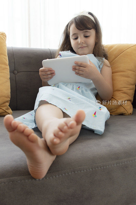 小女孩玩数码平板电脑玩得很开心