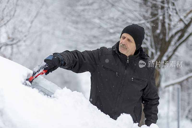 老人从车里刮雪