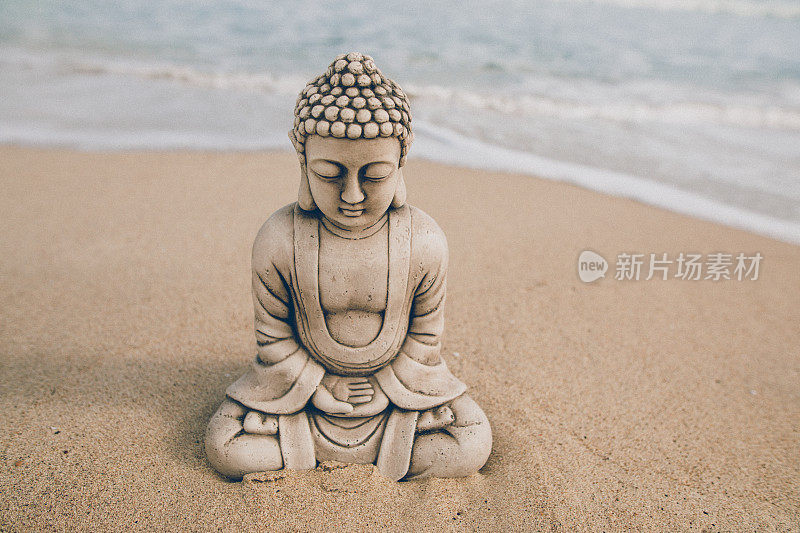 近景佛像石像坐在海边的海滩上