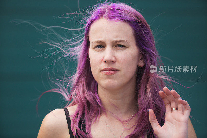 粉红和紫色头发的漂亮年轻女子看起来很焦虑