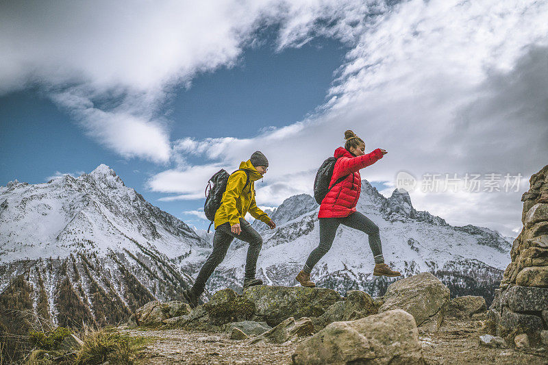 一对年轻的徒步旅行者一起爬上了山脊