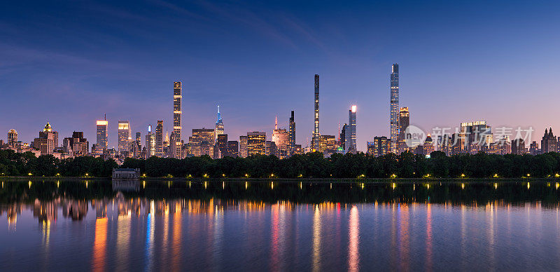 纽约市的天际线。曼哈顿中城的摩天大楼从中央公园水库黄昏。亿万富翁排的超高豪华建筑的夜景