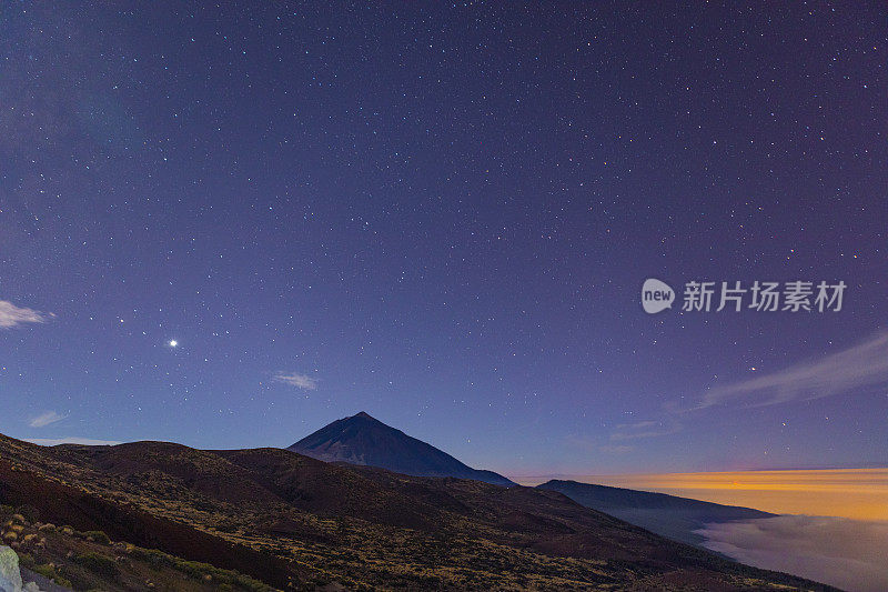 泰德山和海云，夜景拍摄。你可以在地平线上看到康伯Vieja的红光。越过海上的云朵。