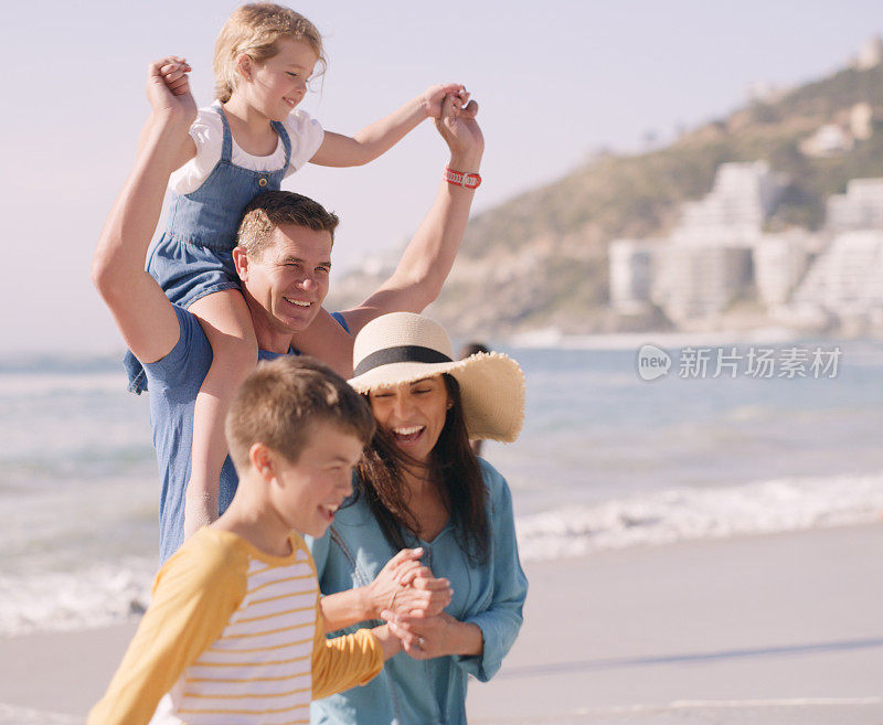 这是一个温馨幸福的家庭在海滩上享受一天的镜头