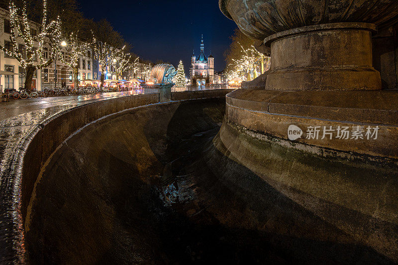 干涸的城市喷泉在迷人的城市广场上灯火通明的历史城市在Overijssel