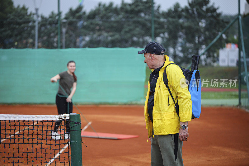 活跃的高年级学生在网球场上和他的网球伙伴告别