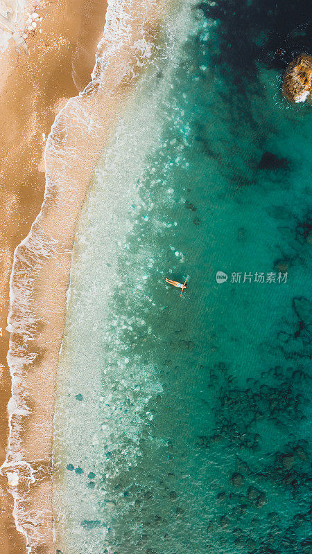 一名女子漂浮在水晶蓝色的海洋与珊瑚礁在土耳其的鸟瞰图