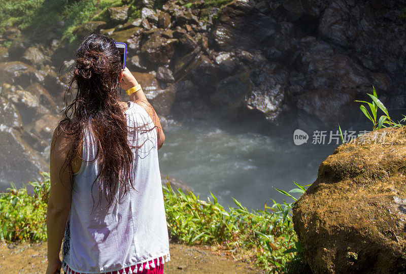 一名年轻女子在瀑布附近预订行程