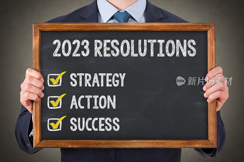 商人在黑板背景上写2023年新年计划