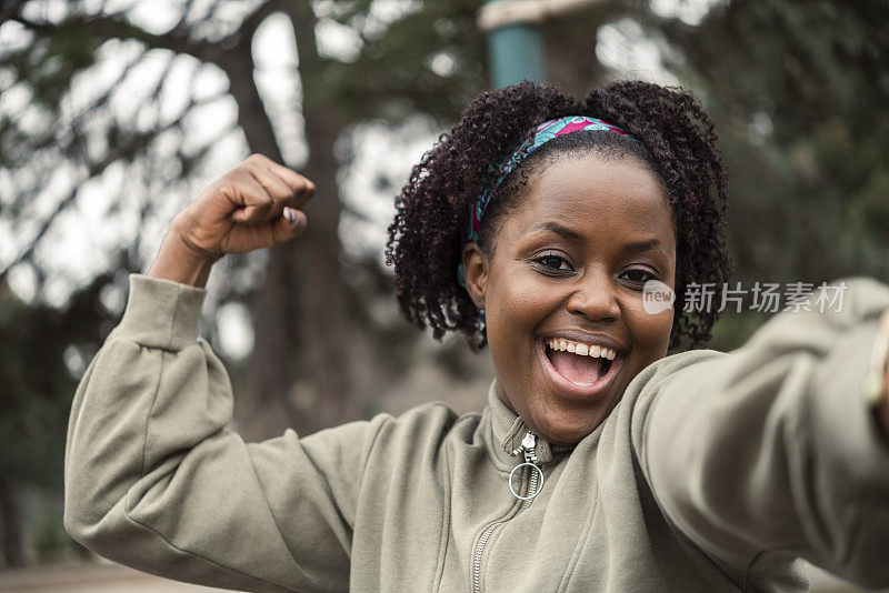 一个快乐的非洲女孩展示肌肉的肖像