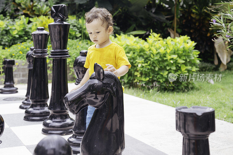 在公园里下巨型象棋的婴儿