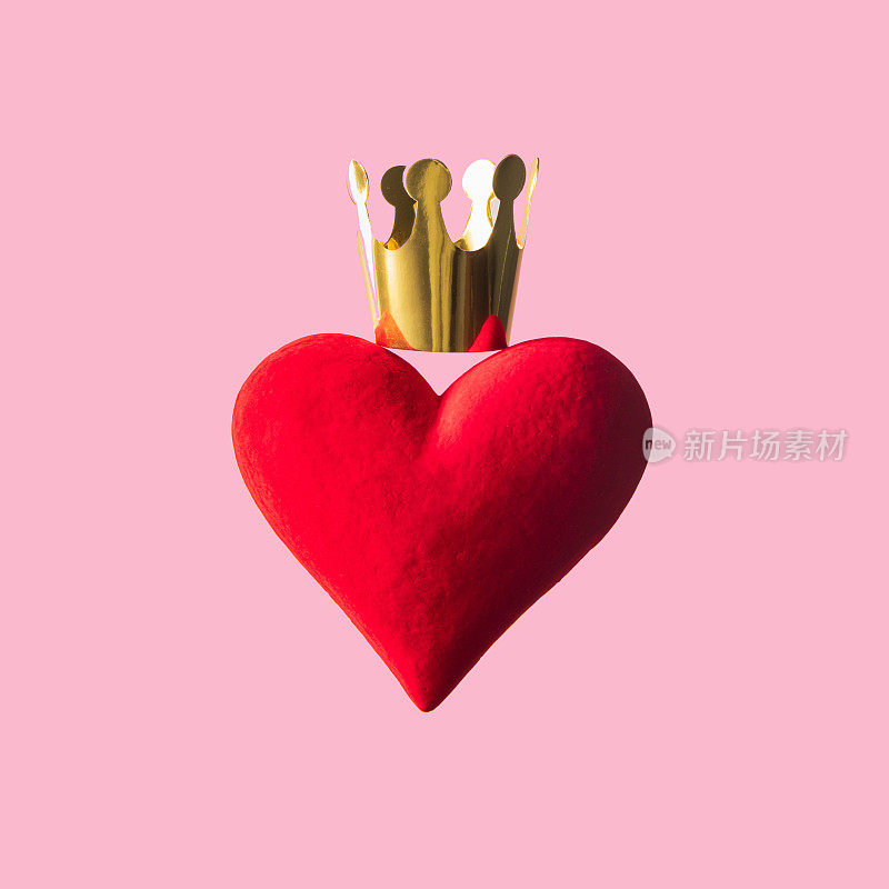 创造性的“爱赢”理念。红色的心和金色的皇冠在淡粉色的背景。现代爱情观念的力量。最小限度的情人节作文。