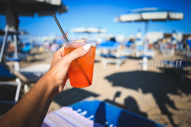 一名女子在意大利海滩上享受饮料。