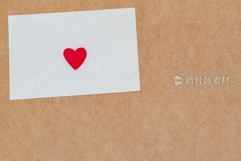 情人节的情书装在一个白色信封里，用红心在木头上封好