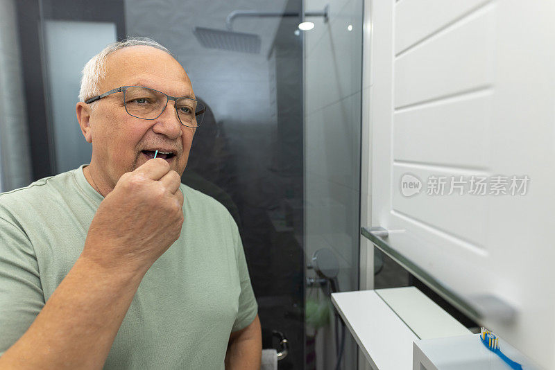 男人在浴室用牙线剔牙