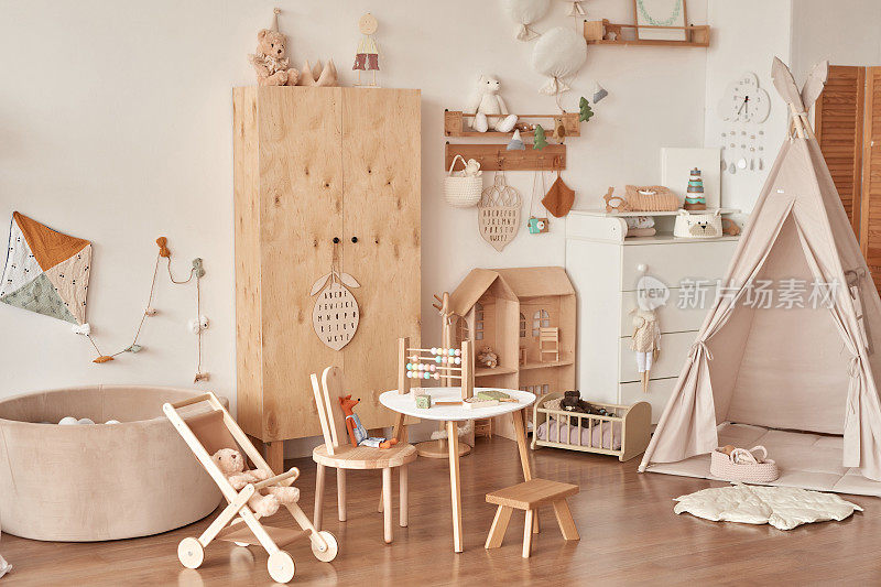 儿童益智木制玩具。育婴室装饰。斯堪的纳维亚风格的游戏室。木制婴儿车，桌子和椅子