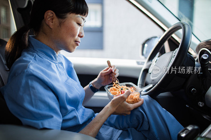 年轻的日本医护人员在车里吃午饭