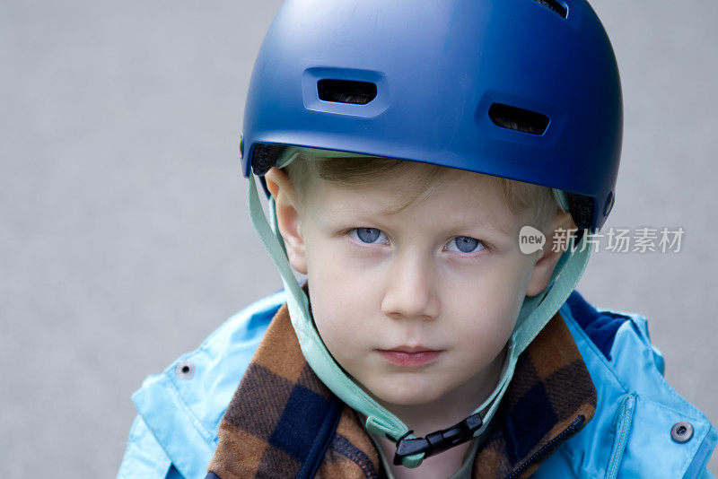 戴着自行车头盔的小男孩看着相机复制空间