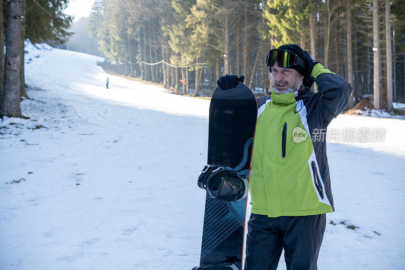 老人:头发花白、蓄着胡须、穿着冬季运动服、倚在滑雪板上的老人