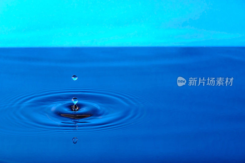 飞溅的水与发散水圈，在蓝色的背景。