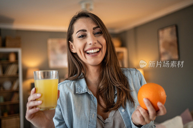 一位年轻女子享受着喝鲜橙汁的时刻