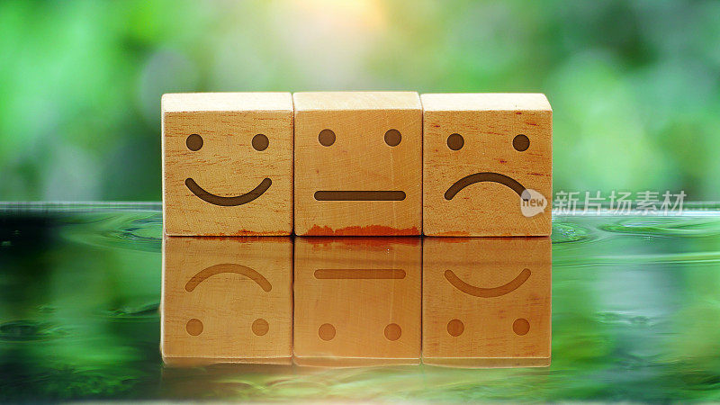 圆木上刻着快乐、平淡和愤怒的面孔。顾客评价概念，情商，情绪控制平衡，反馈评估，心理健康评估。