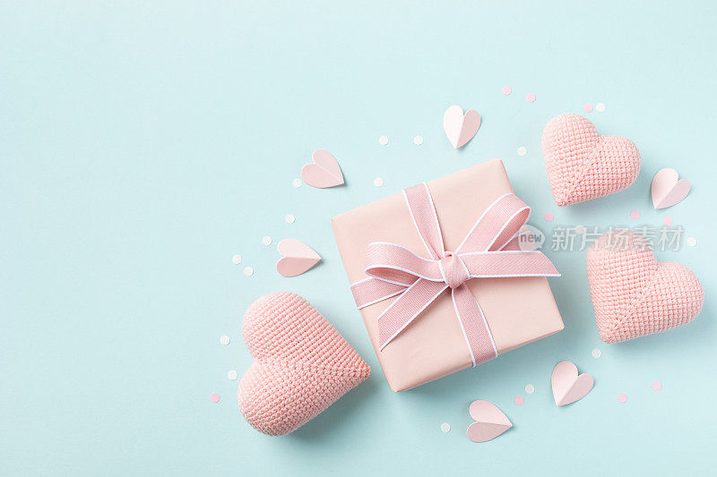 生日，女人或母亲节贺卡。粉红色的心和礼盒上的蓝色粉彩桌面视图。