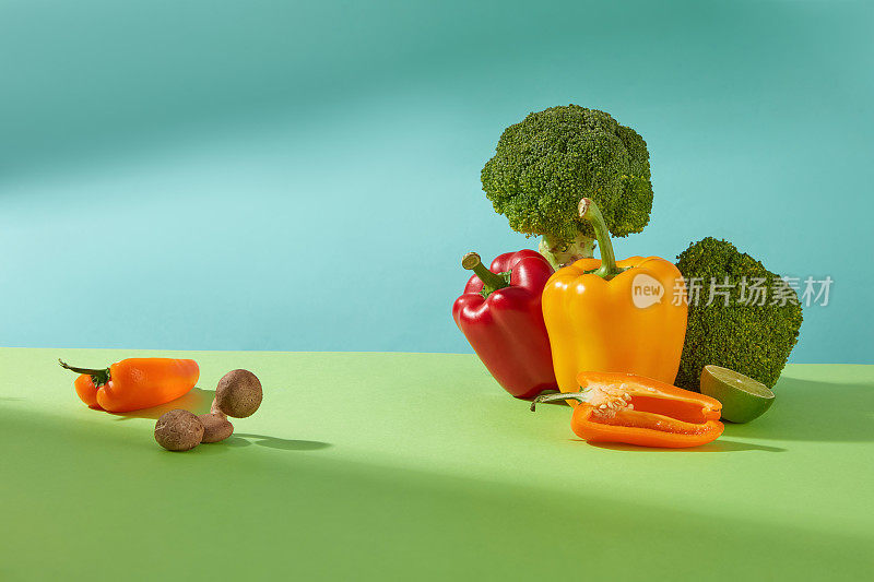 新鲜蔬菜烹饪饮食或素食与花椰菜，辣椒，酸橙和一些蘑菇在蓝色的光背景。拷贝空间，前视图
