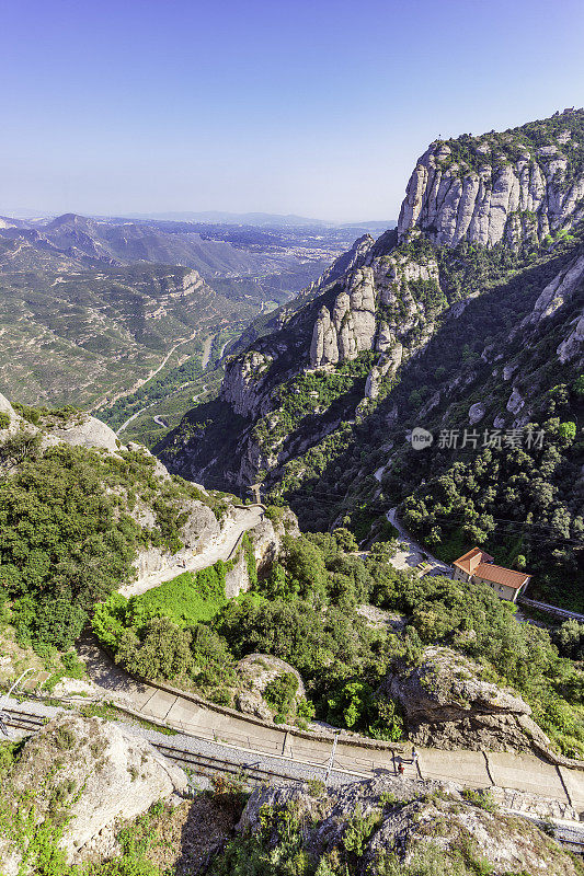 从西班牙加泰罗尼亚蒙特塞拉特的蒙特塞拉特山上俯瞰，你可以看到服务于这个热门旅游目的地的轨道交通和缆车系统。