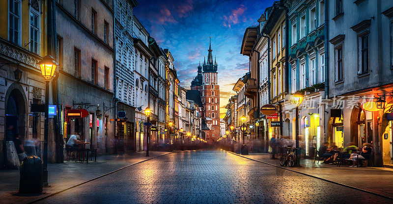 波兰克拉科夫老城弗洛里安斯卡大街上的圣玛丽大教堂的夜景。全景，长曝光，延时。