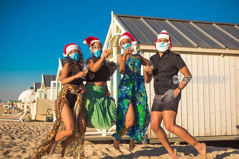 在冠状病毒大流行期间，四个朋友在海滩上庆祝圣诞节