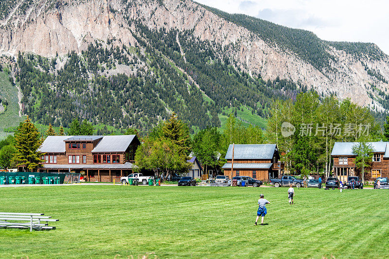 科罗拉多州的村庄在夏天与镇公园和人们踢足球在草地上的足球运动在市中心的房子建筑