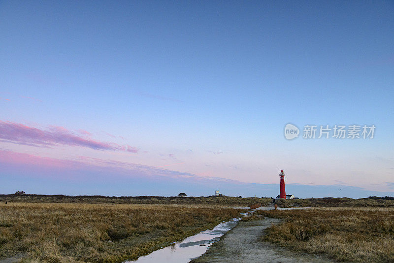 日落时分，瓦登西地区的Schiermonnikoog岛沙丘上的灯塔