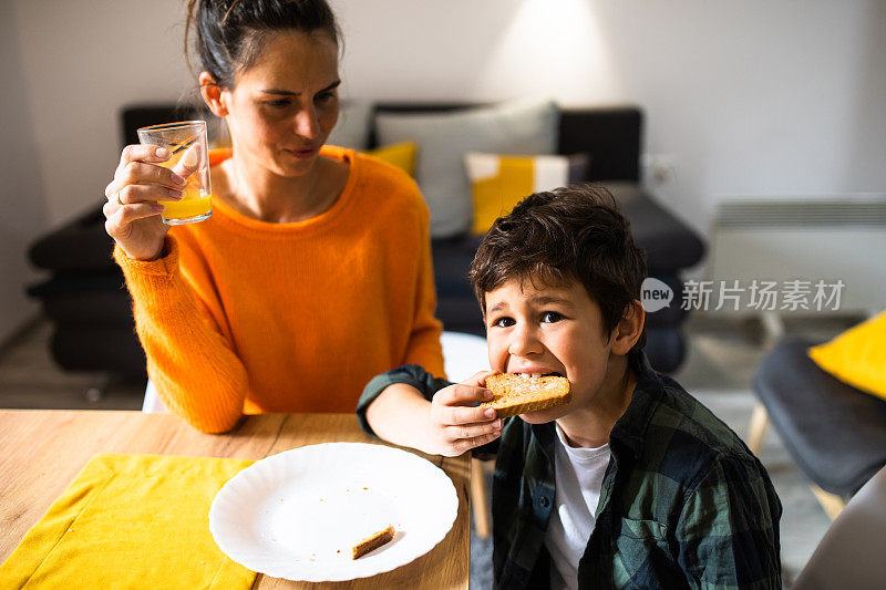 母亲和儿子正在吃早餐