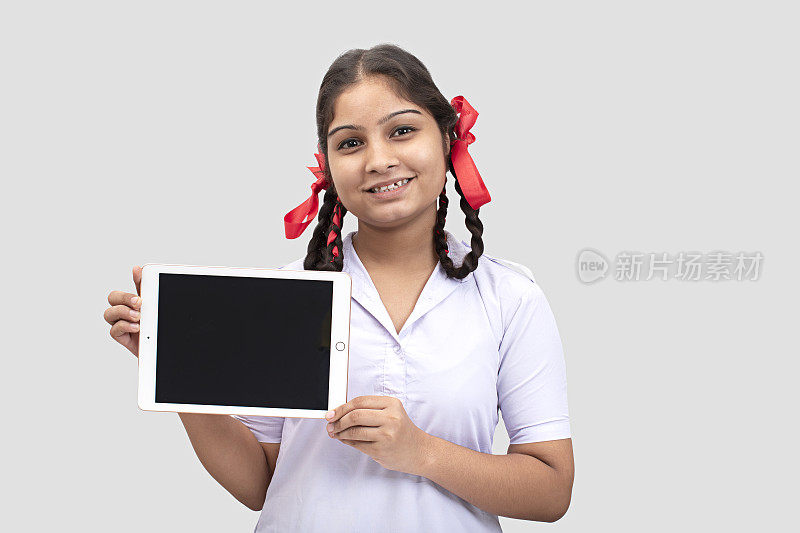 农村上学女孩展示数码平板电脑库存照片