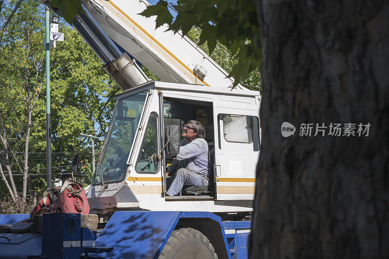 成熟的建筑工人操作起重机