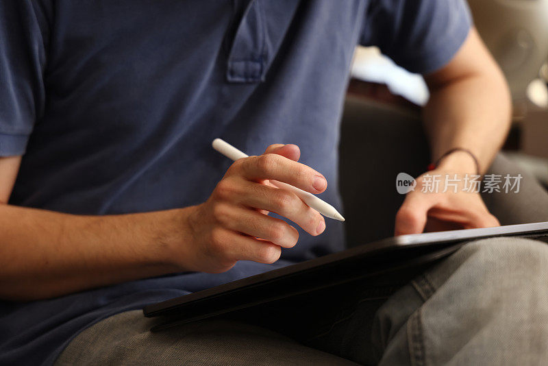 特写的男性手使用数字笔书写在数字平板屏幕上