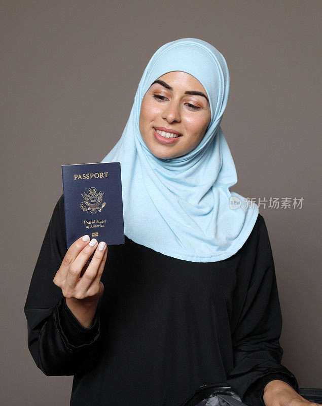 一名中东妇女看着护照微笑