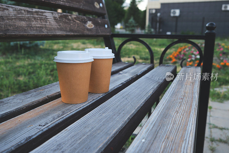 两杯咖啡带走在公园的木凳上